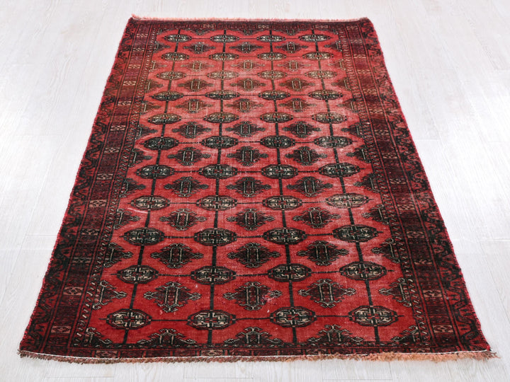 a red and black rug on a white floor