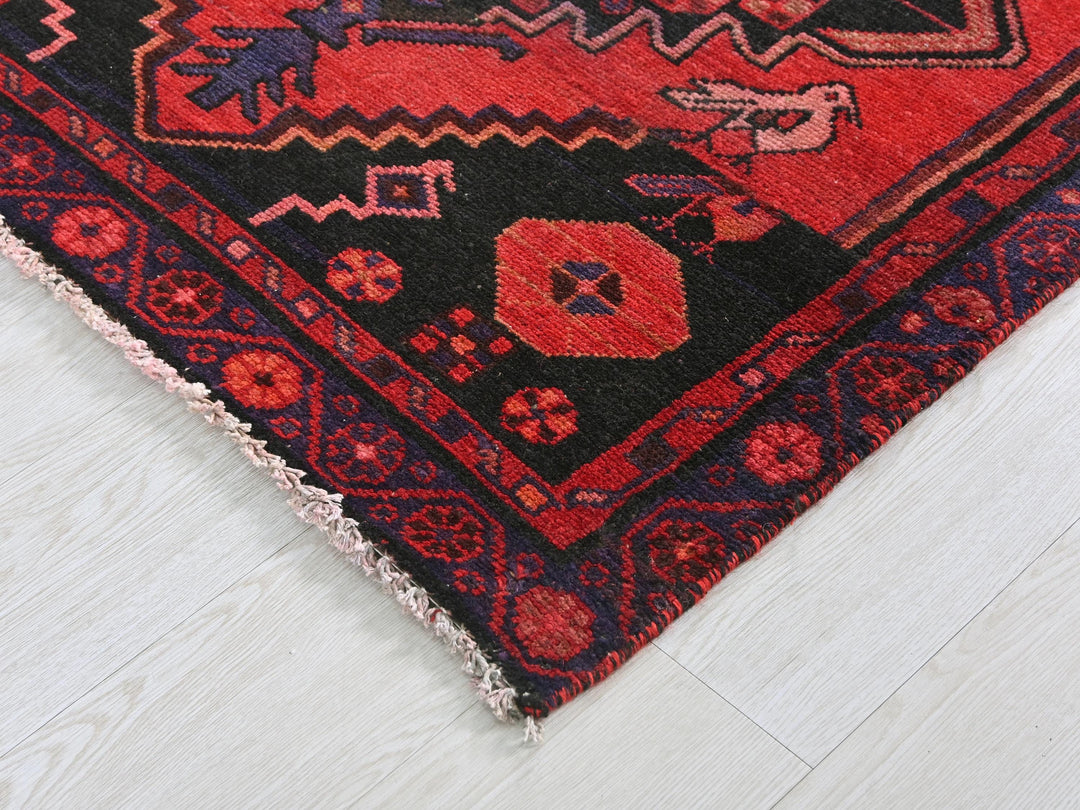 a red and black oriental rug on a white floor