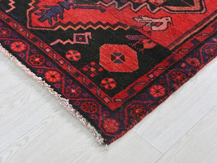 a red and black oriental rug on a white floor
