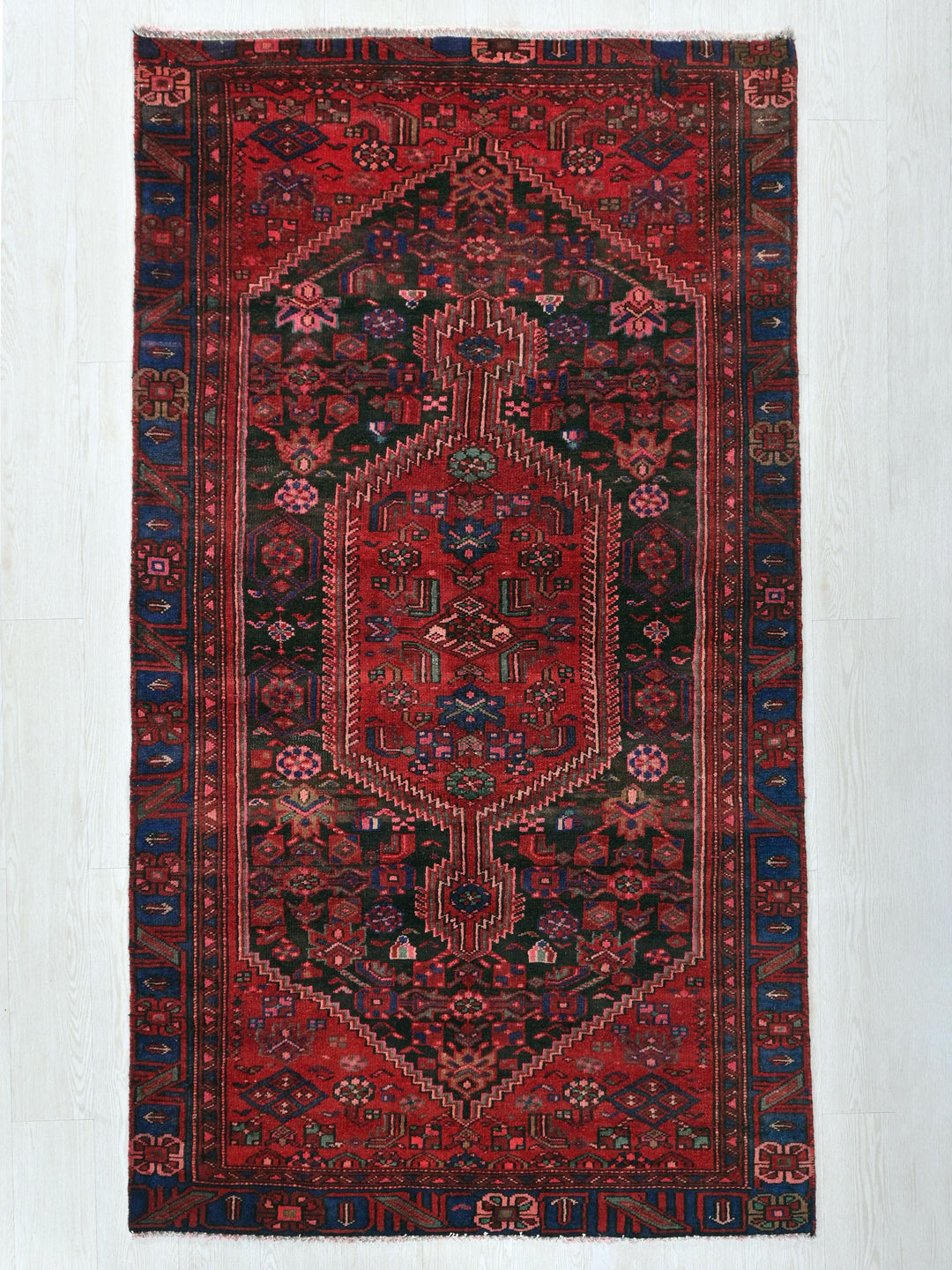 a red rug with a design on the middle of it