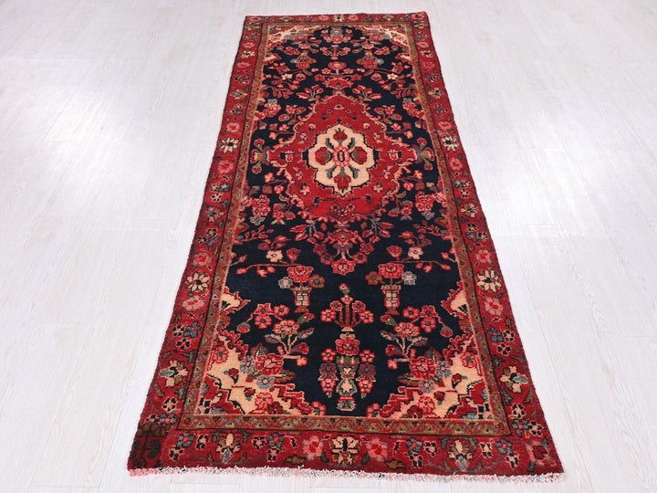 a red and black rug on a white floor