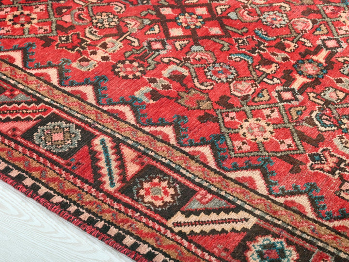 a red rug with a multicolored design on it