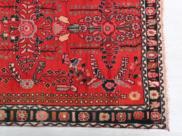 a red oriental rug with a black border