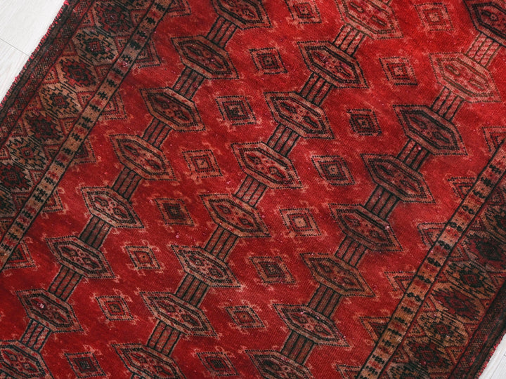 a red and black rug on a white floor