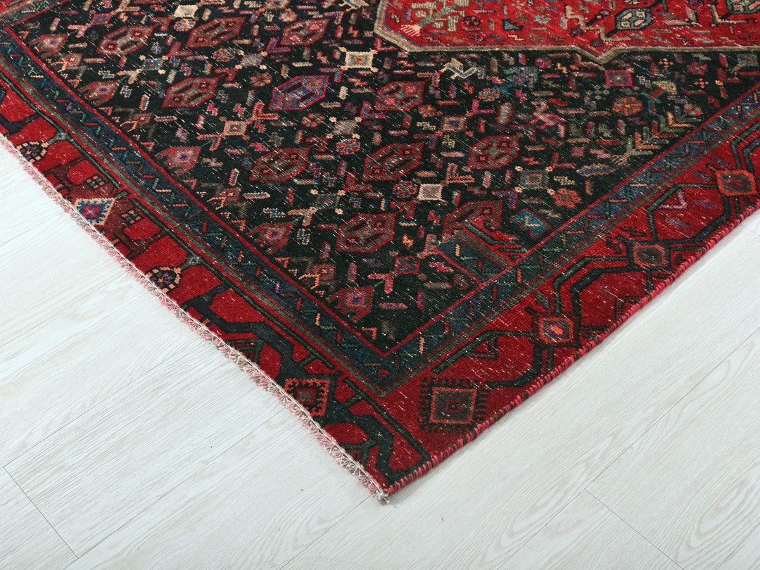a red and black oriental rug on a white floor
