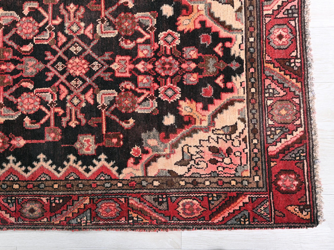 a red and black oriental rug on a white floor