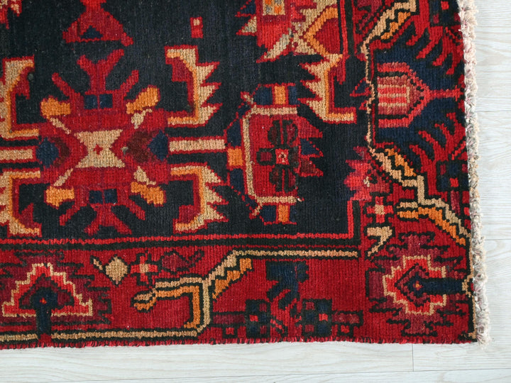 a red and black rug on a white surface