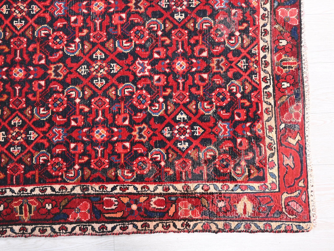 a red and black oriental rug on a white floor