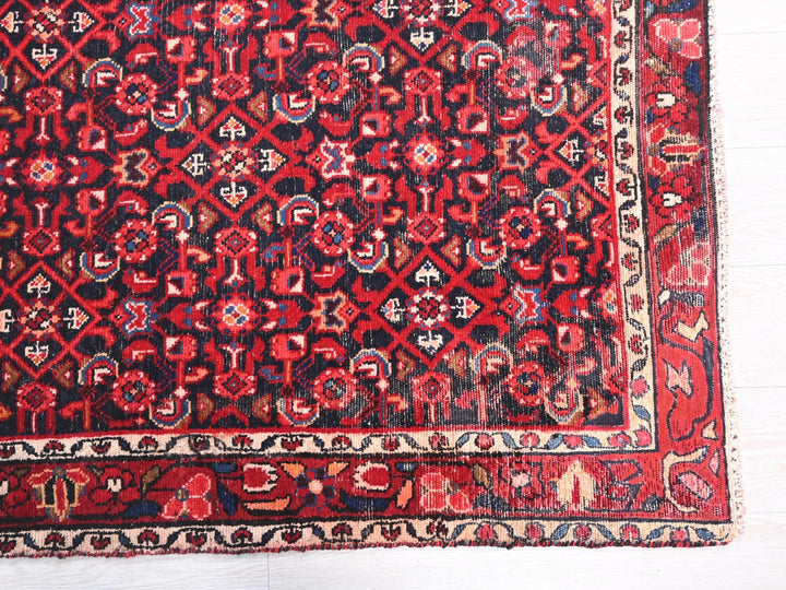 a red and black oriental rug on a white floor