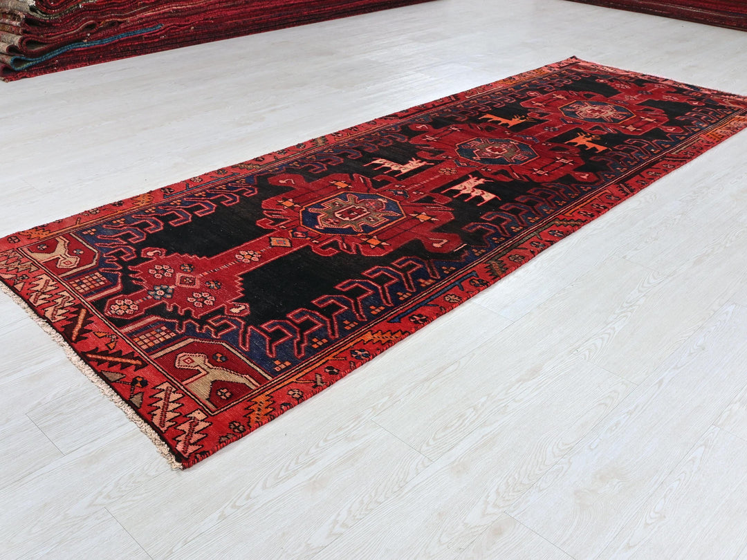 a red and black rug on a white floor