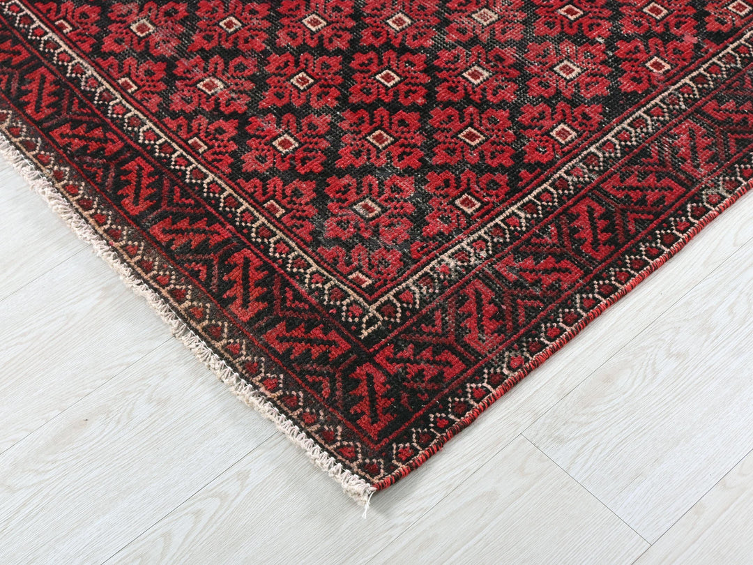 a red and black rug on a white floor