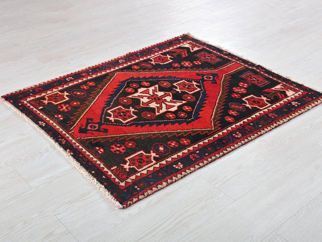 a red and black rug on a white floor