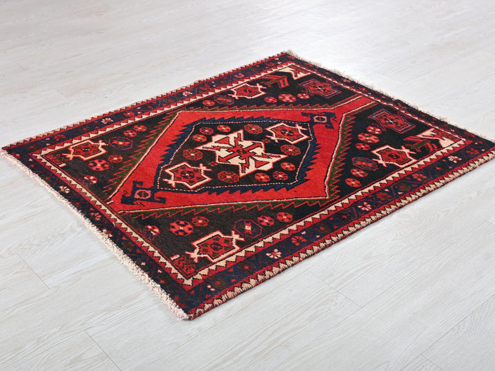a red and black rug on a white floor