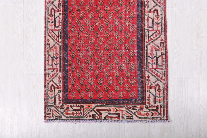 a red rug on a white wooden floor
