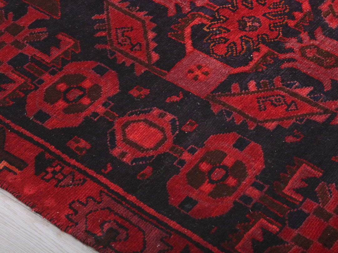 a close up of a red and black oriental rug