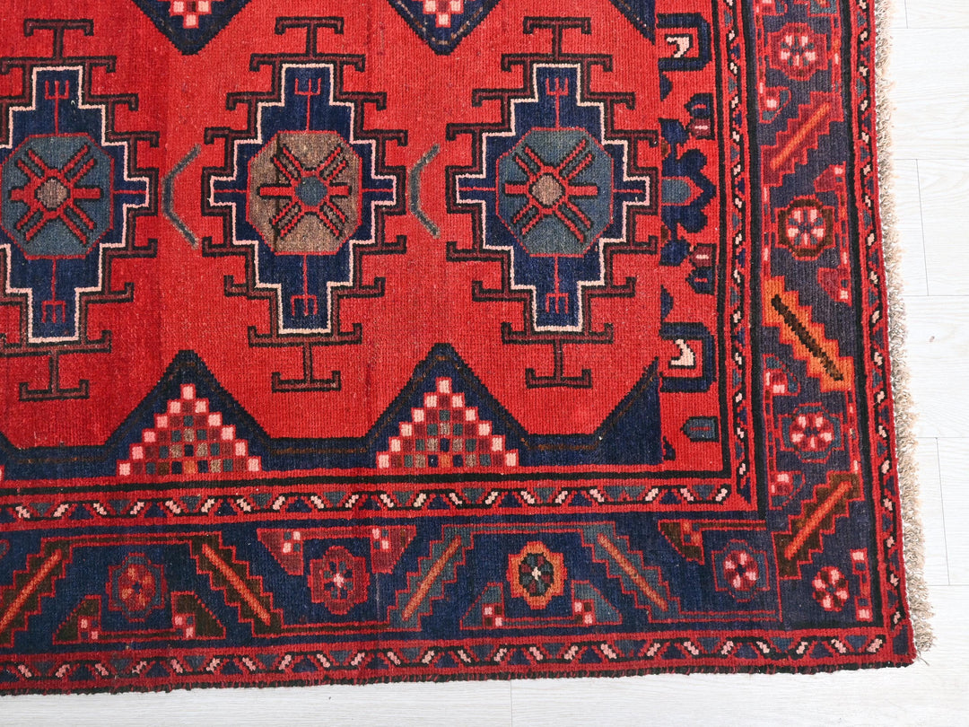 a red rug with blue and red designs on it