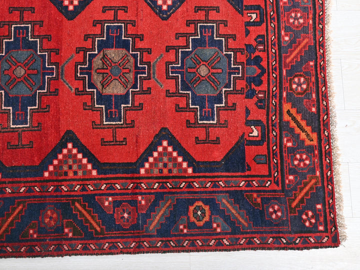 a red rug with blue and red designs on it