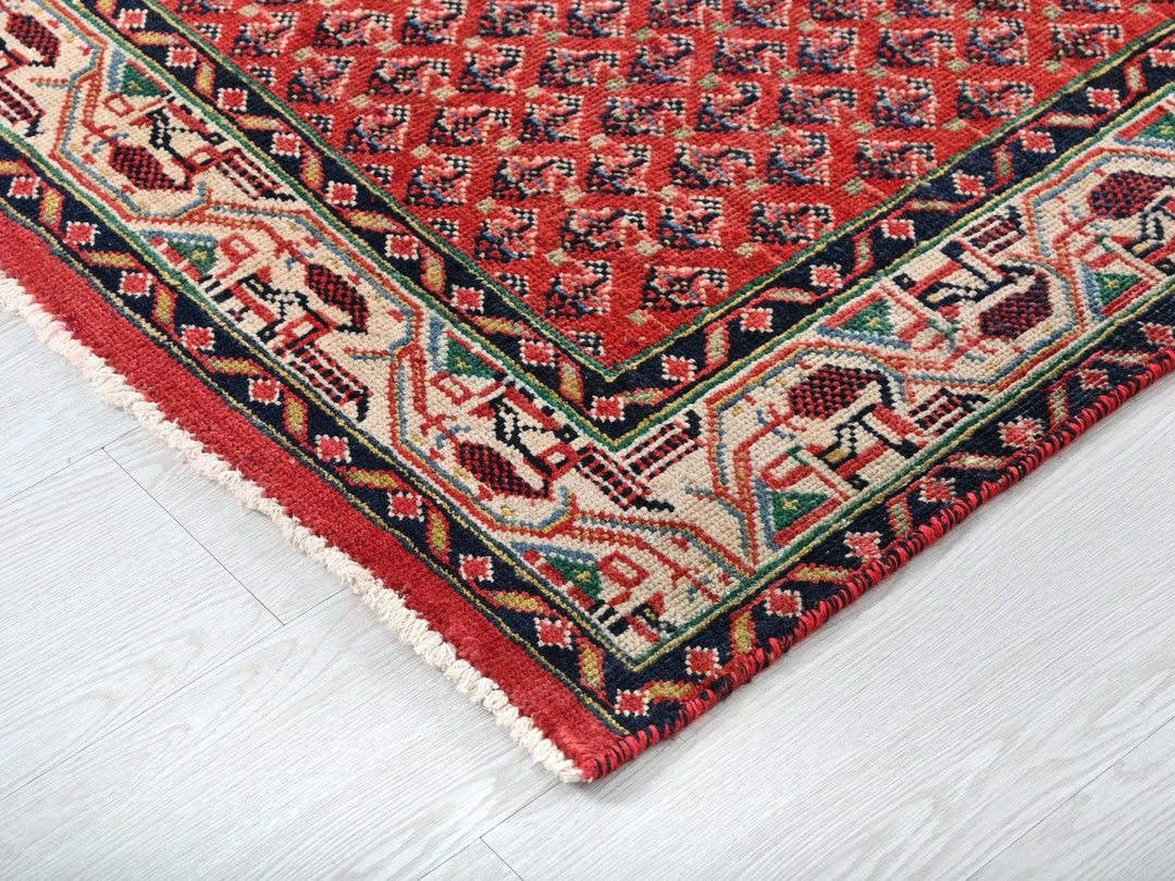 a red rug on a white wooden floor