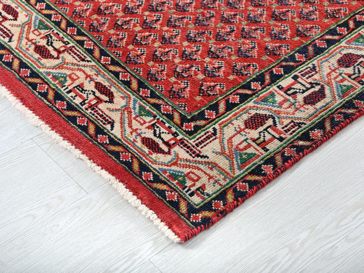 a red rug on a white wooden floor