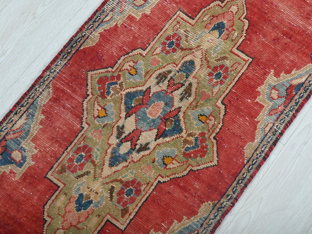 a red rug on a white wooden floor