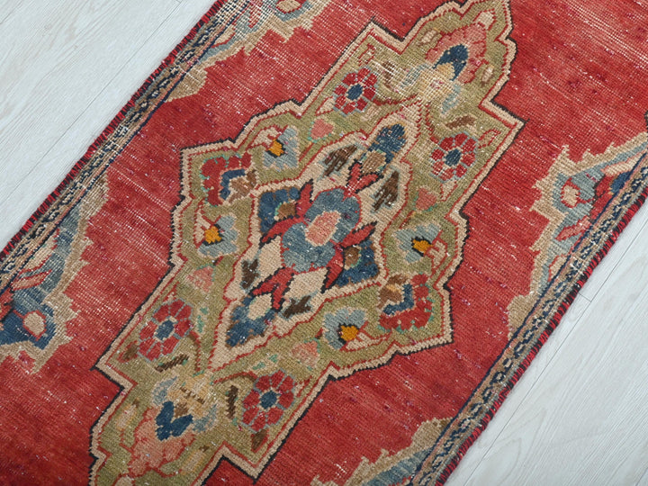a red rug on a white wooden floor