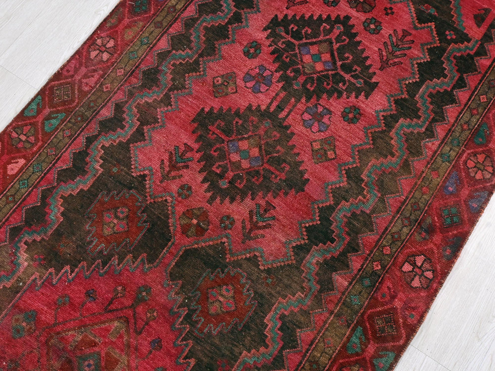 a red rug with a design on the middle of it