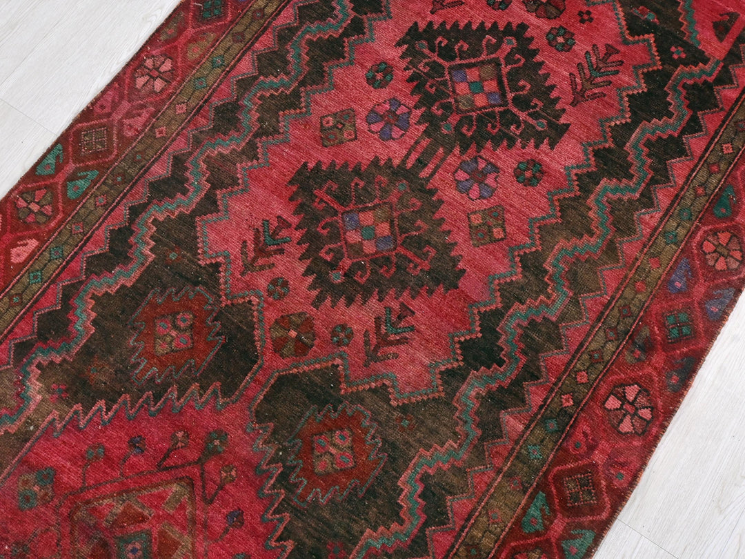 a red rug with a design on the middle of it