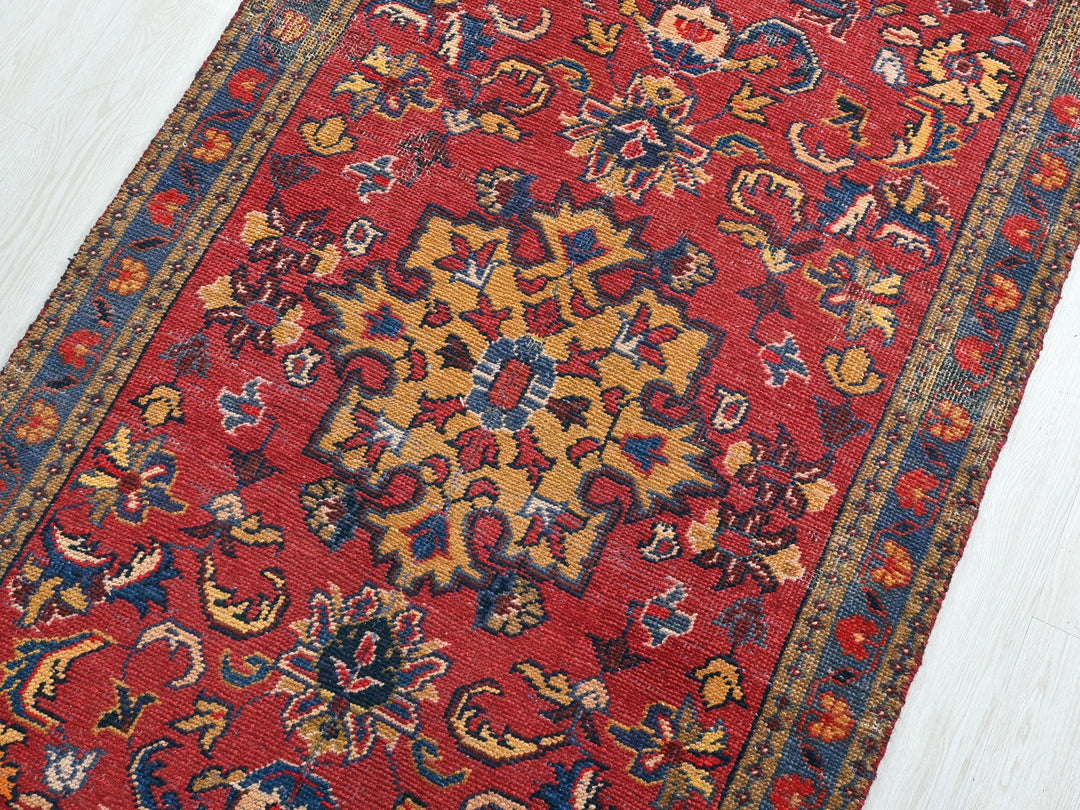 a red rug with a yellow and blue design on it