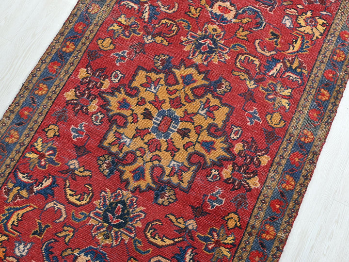 a red rug with a yellow and blue design on it
