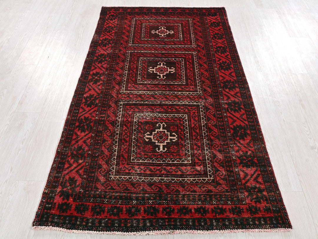 a red and black rug on a white floor