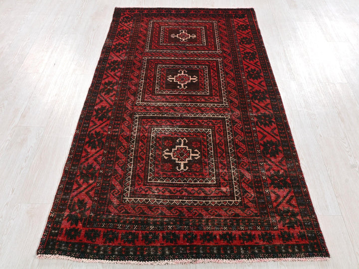 a red and black rug on a white floor