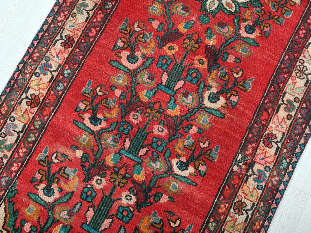 a red rug with a tree of life design on it
