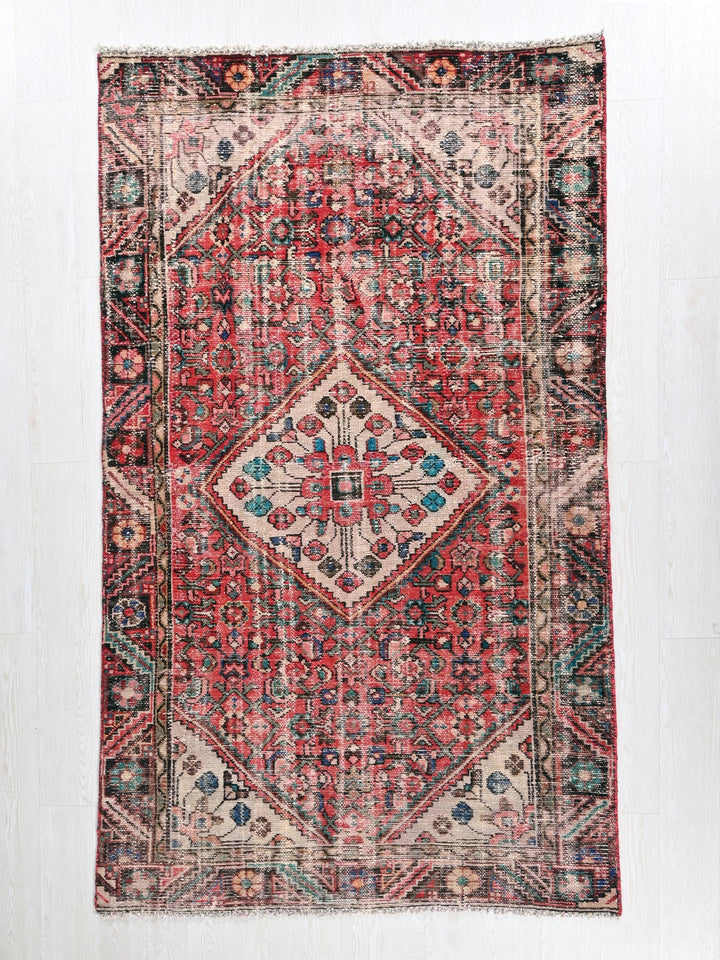 a red and blue rug with a diamond pattern