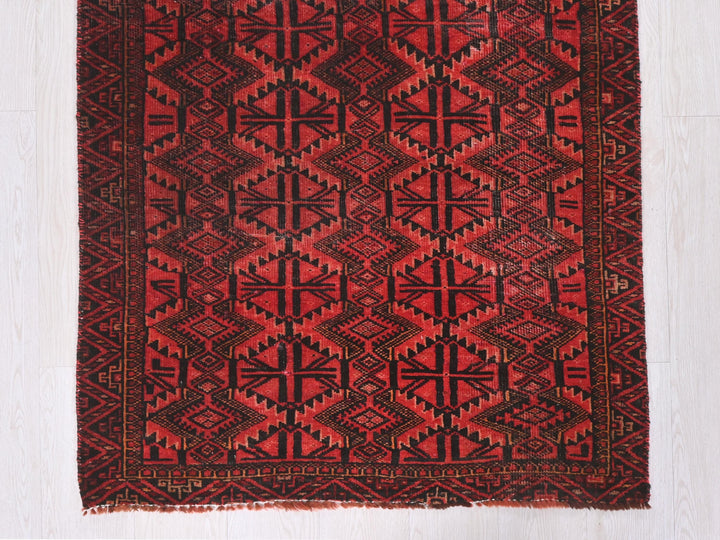 a red and black rug on a white floor