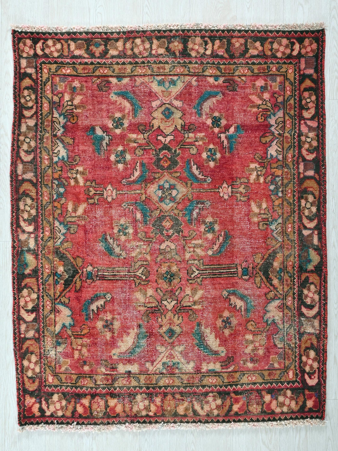 a red rug with a floral design on it