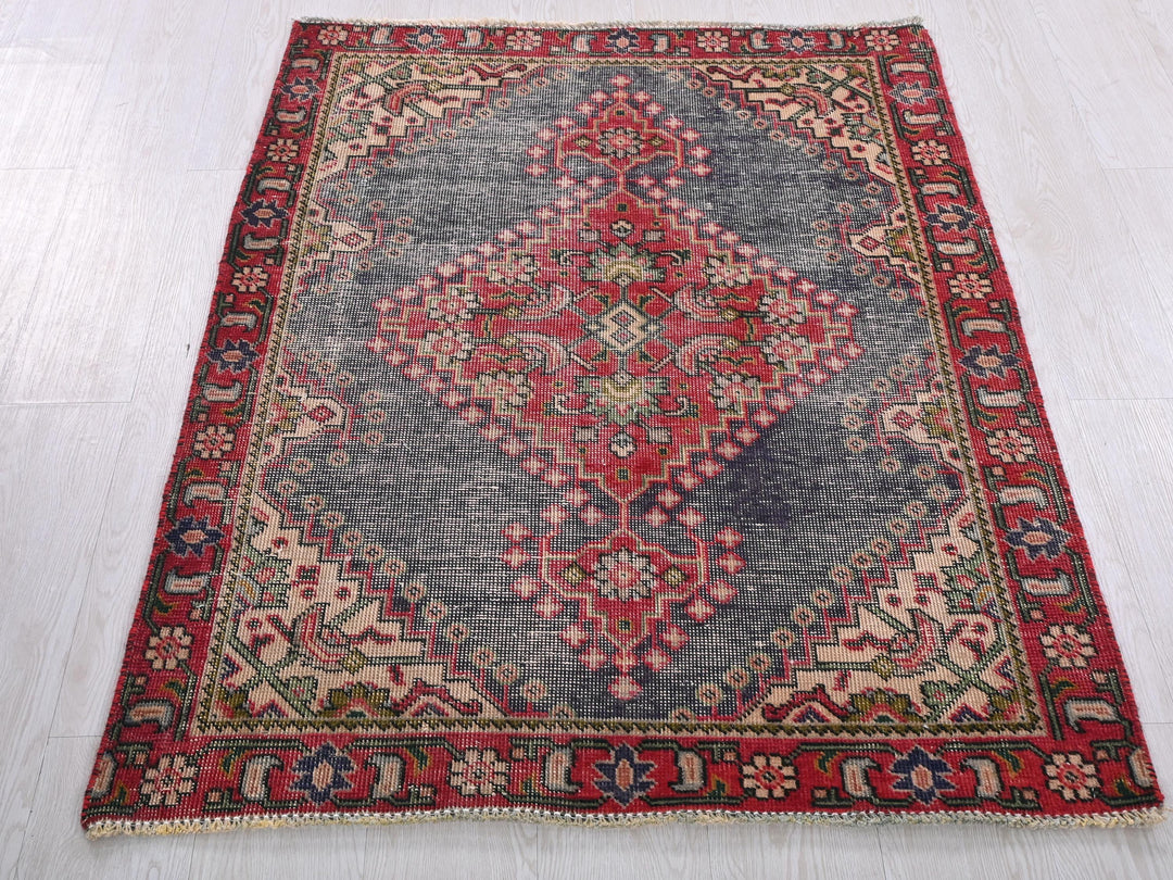 a red and blue rug on a white floor