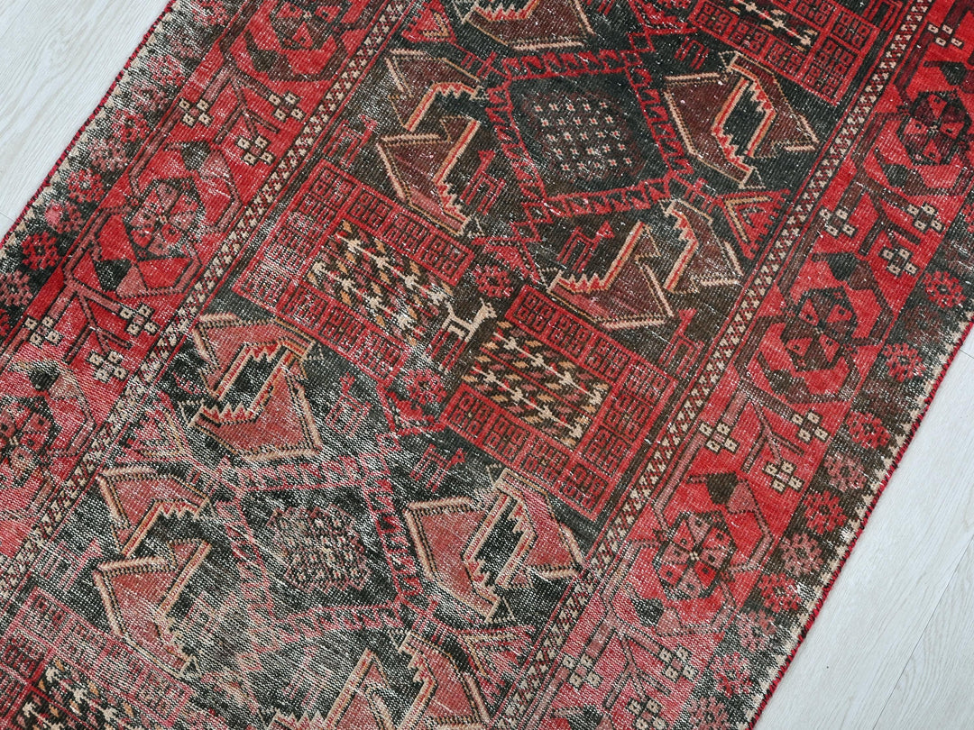 a red and black rug on a white floor