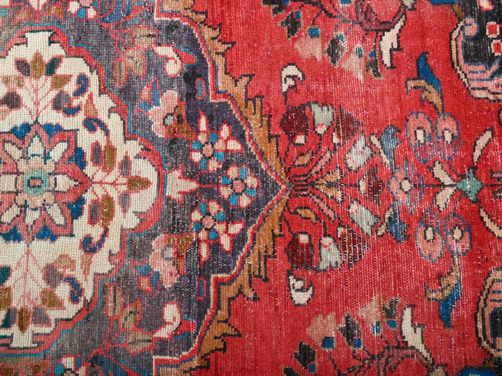 a red oriental rug with a floral design
