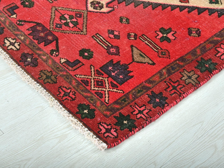 a red rug on a white wooden floor