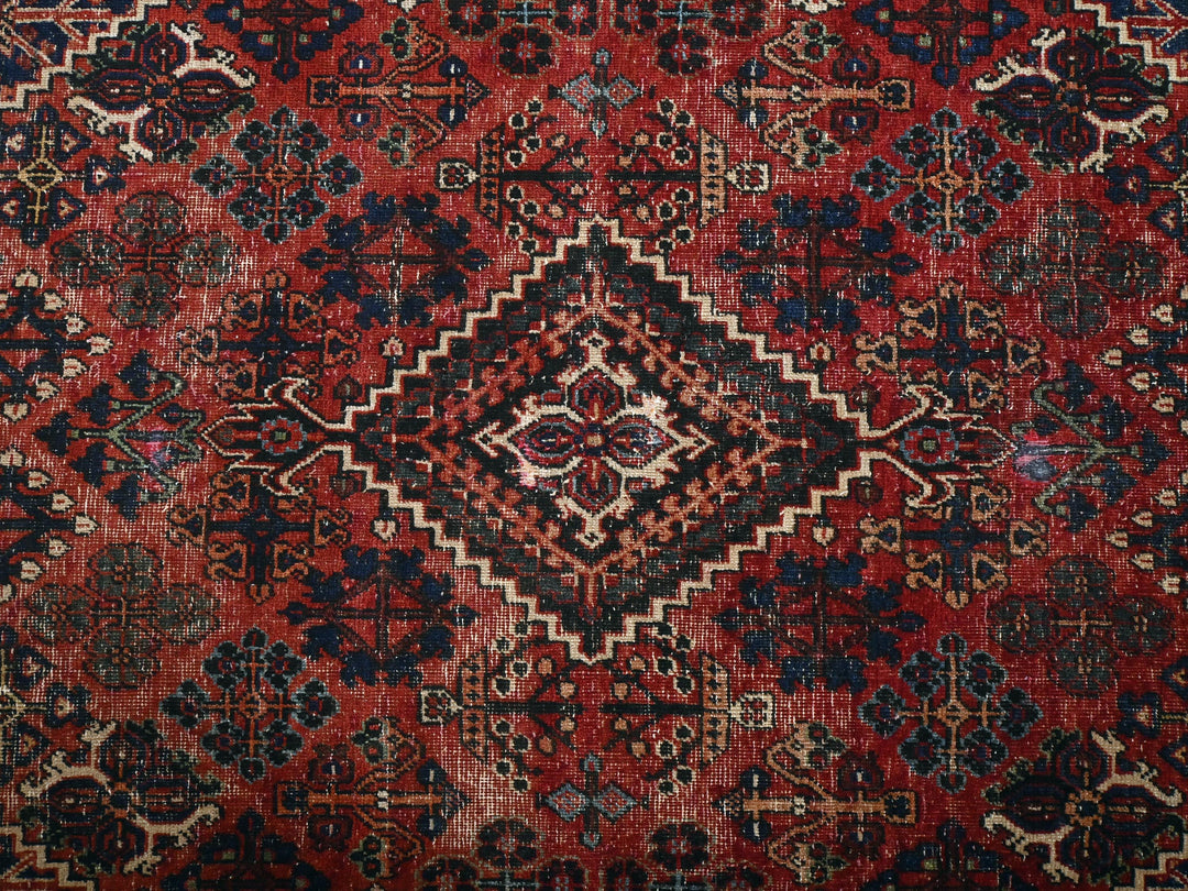 a red and blue rug with a diamond pattern