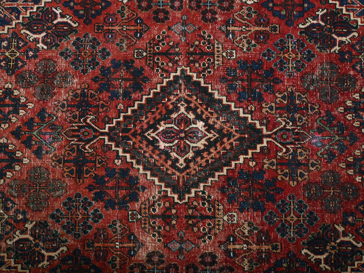 a red and blue rug with a diamond pattern