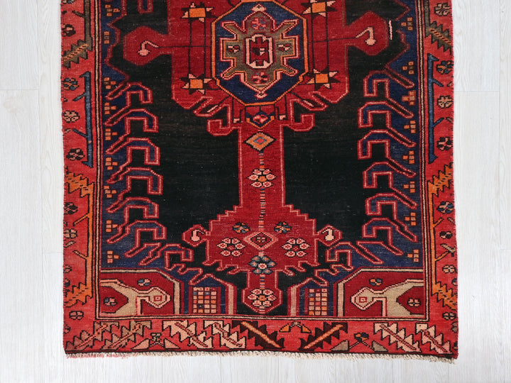 a red and black rug with a design on it