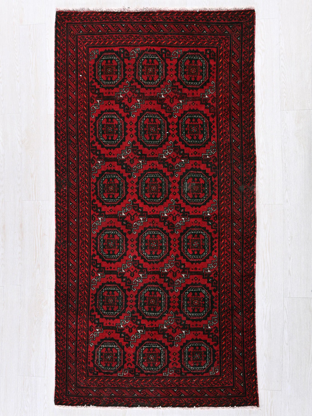 a red and black rug on a white floor