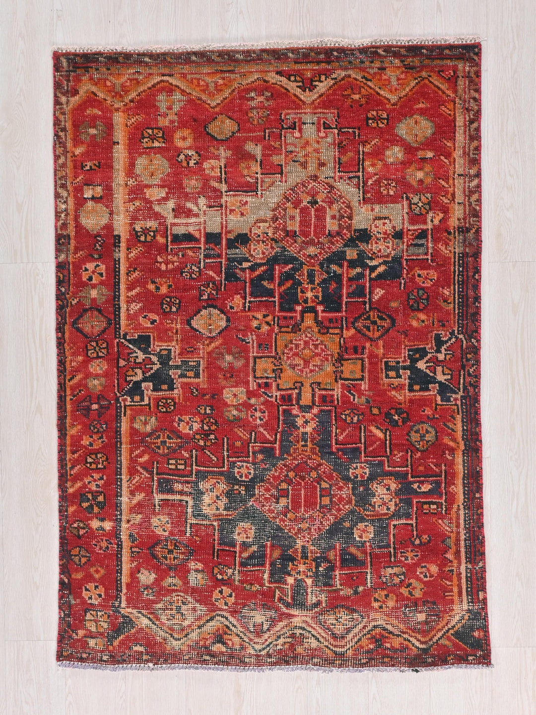 a red rug with a pattern on the middle of it