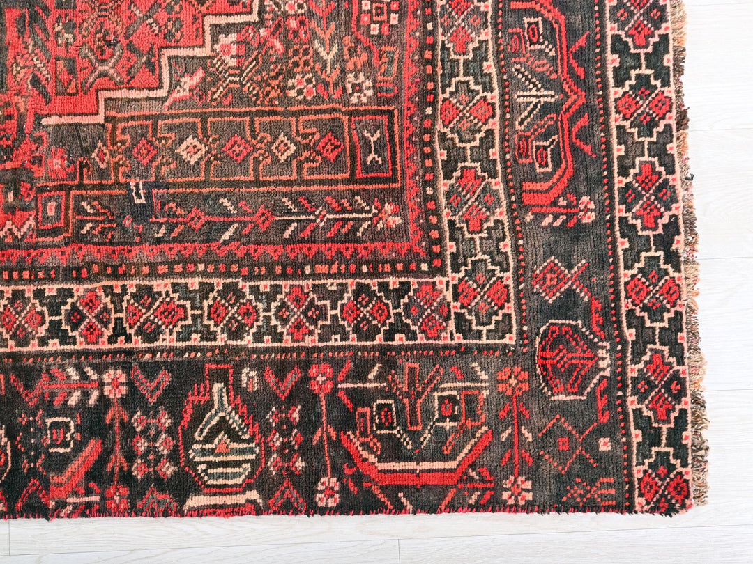 a red and black rug with a design on it