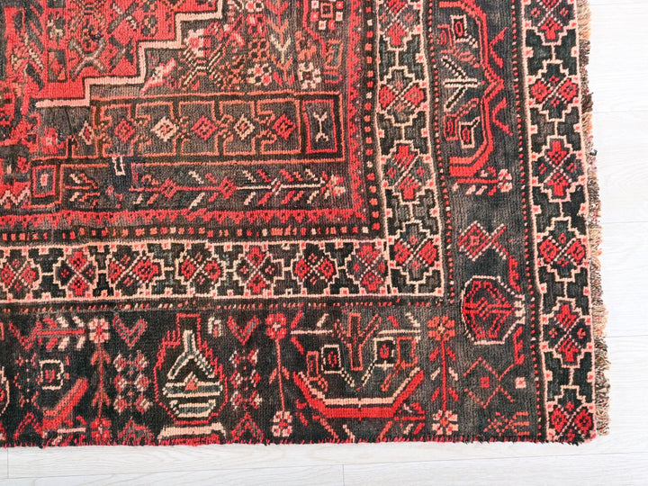 a red and black rug with a design on it
