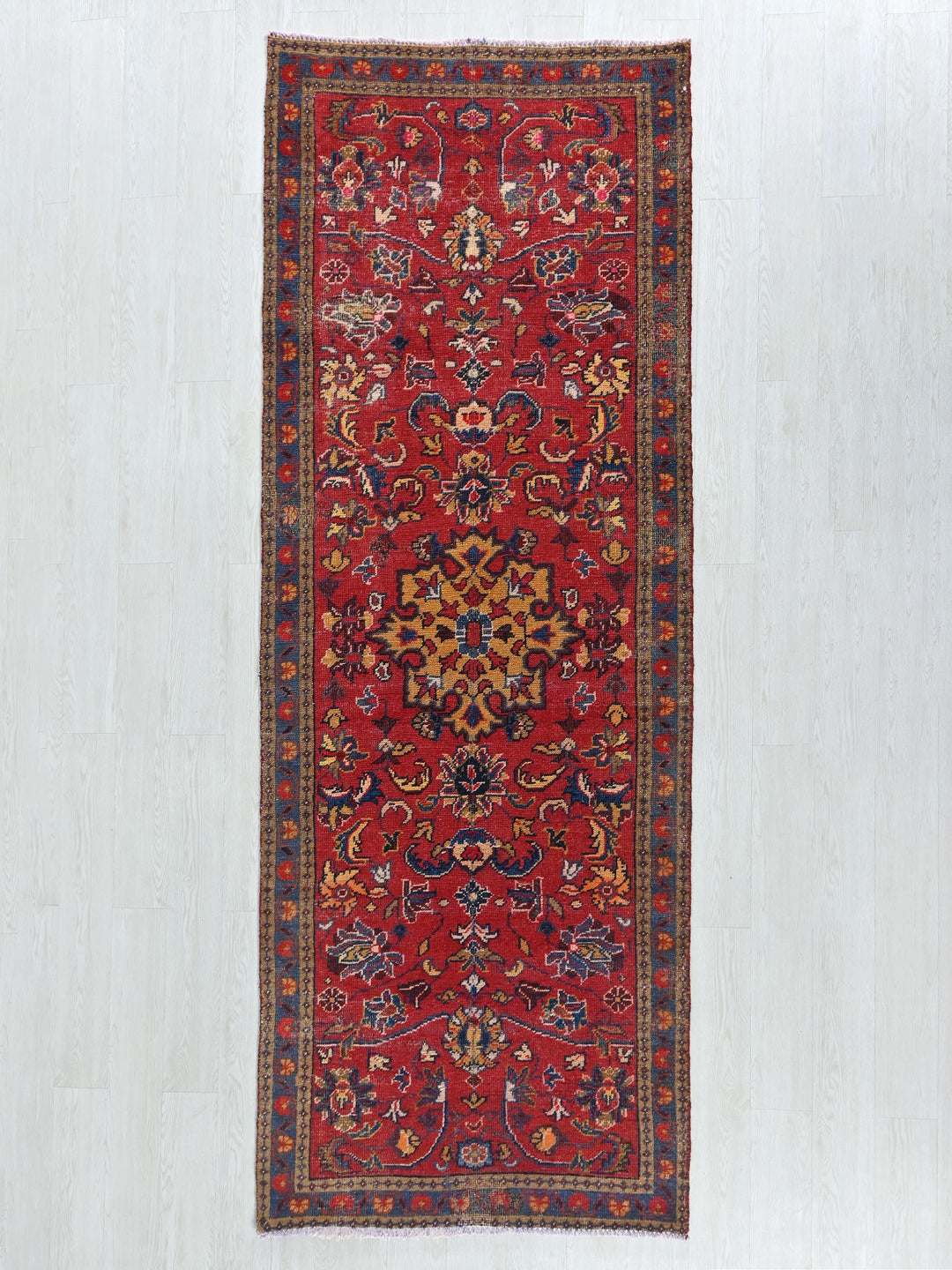 a red rug with a floral design on a white background