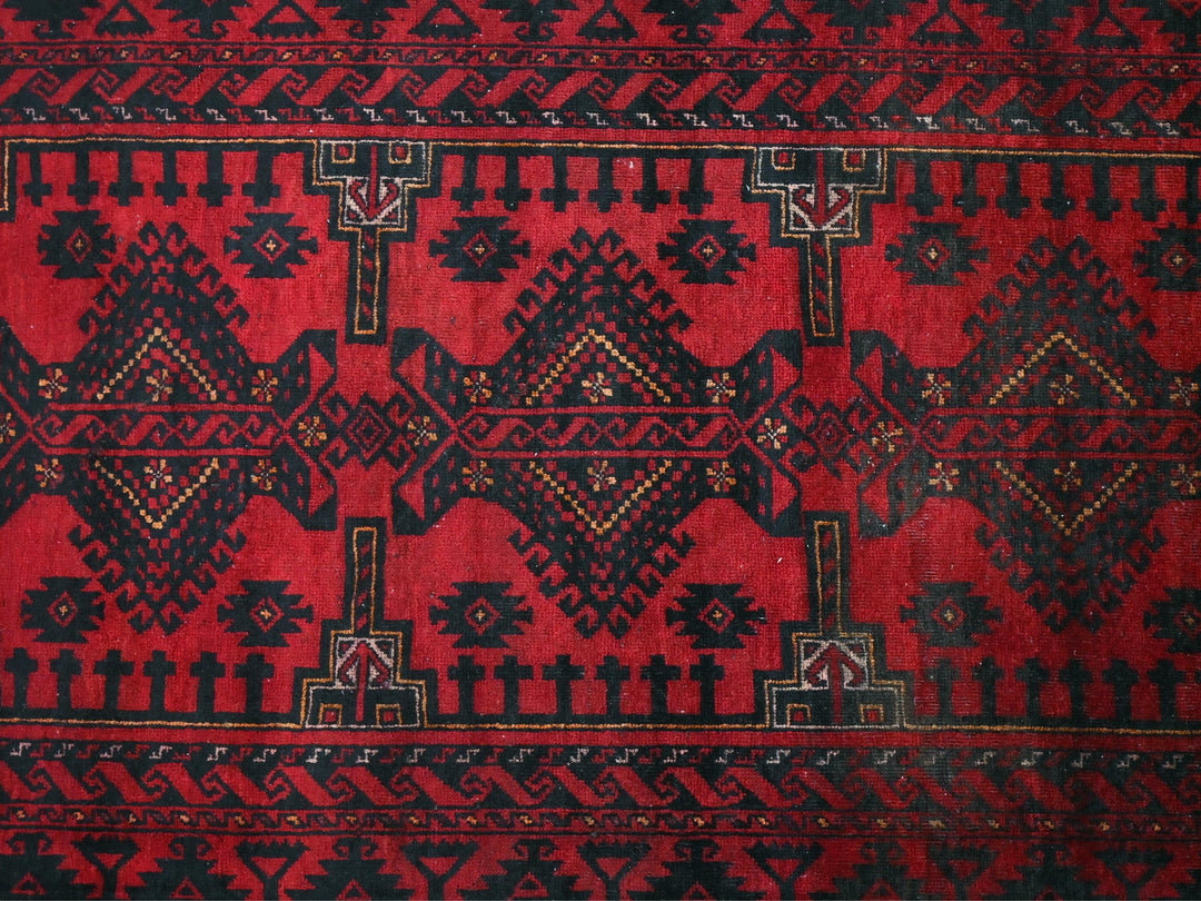 a red and black rug with a design on it