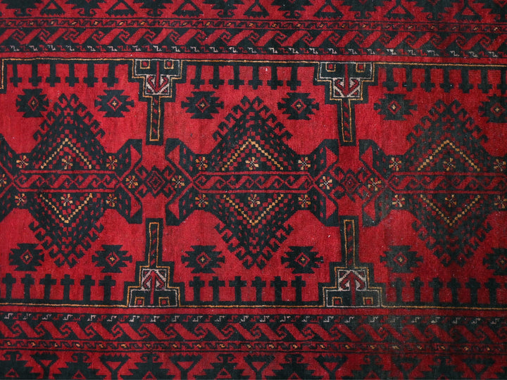 a red and black rug with a design on it