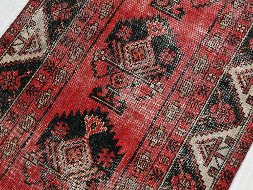 a red rug with a black and white design on it